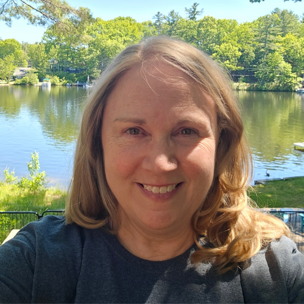 Professional headshot of Stephanie Garde, Director of Operations at the Attachment and Trauma Network outside with lake background.